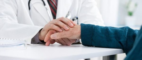 doctor placing his hands on patients hand