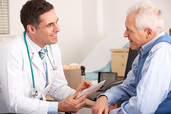 male doctor talking to older patient