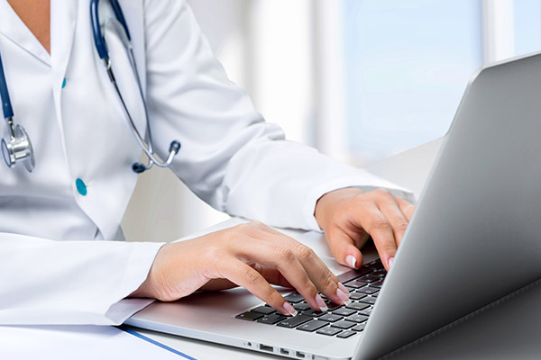 doctor typing on laptop during virtual medicine appointment